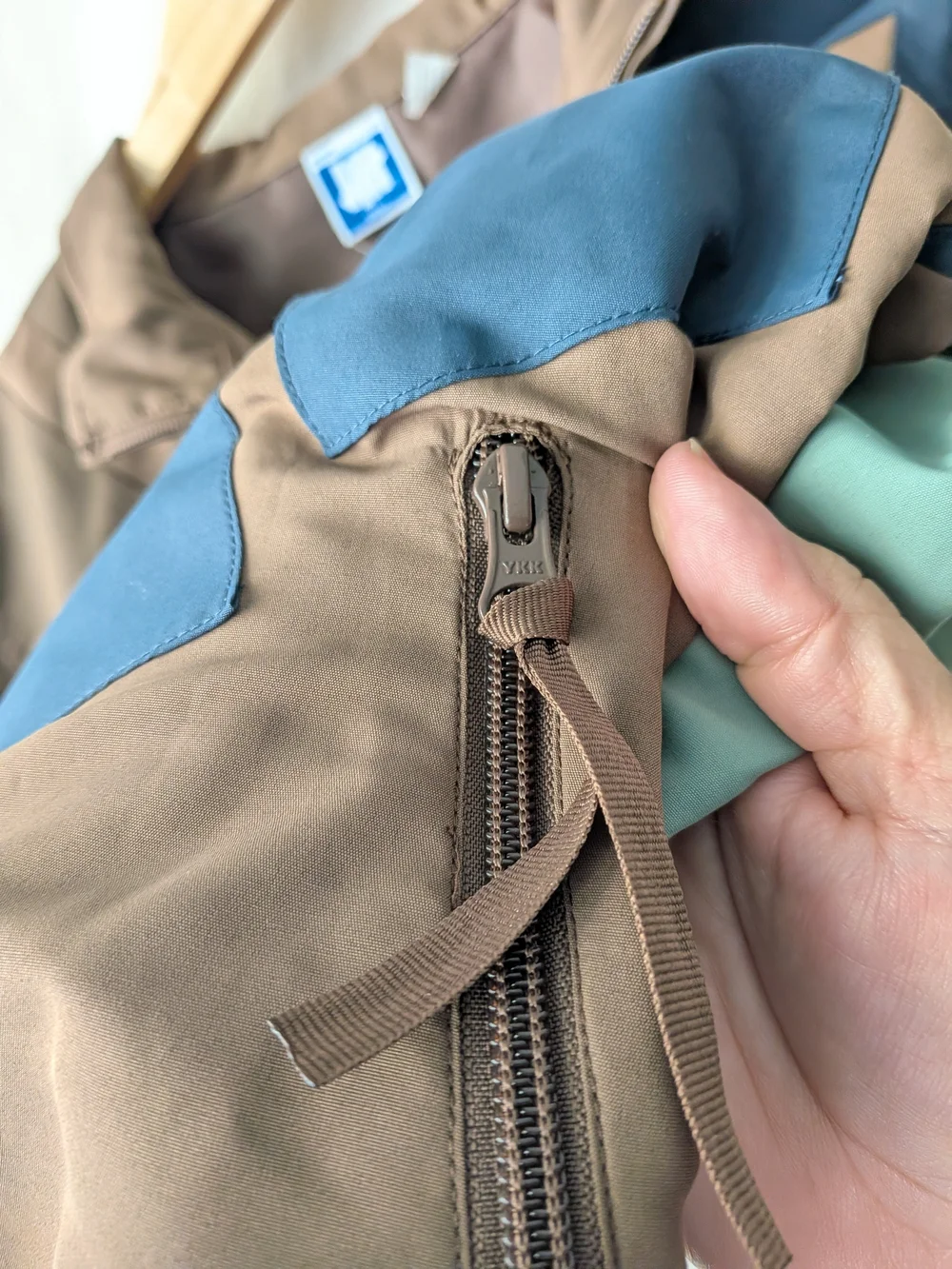Undefeated Jacket in Taupe and Beige with Blue Logo Tag